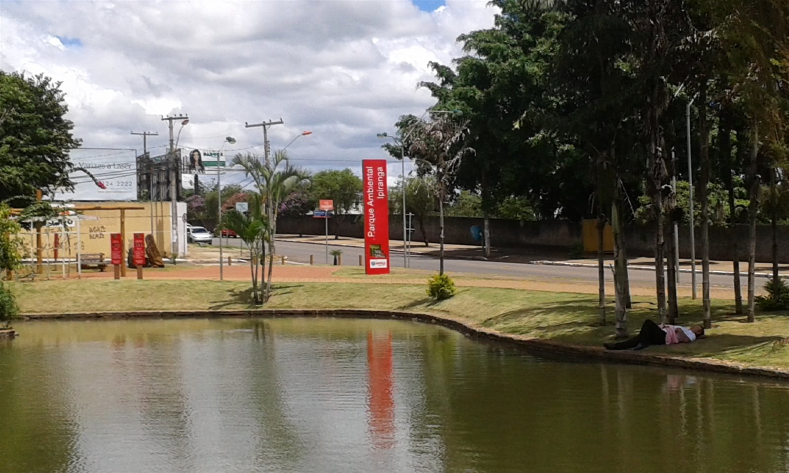 Lago do Parque Ambiental Ipiranga, com a placa vermelha do parque e árvores ao fundo.