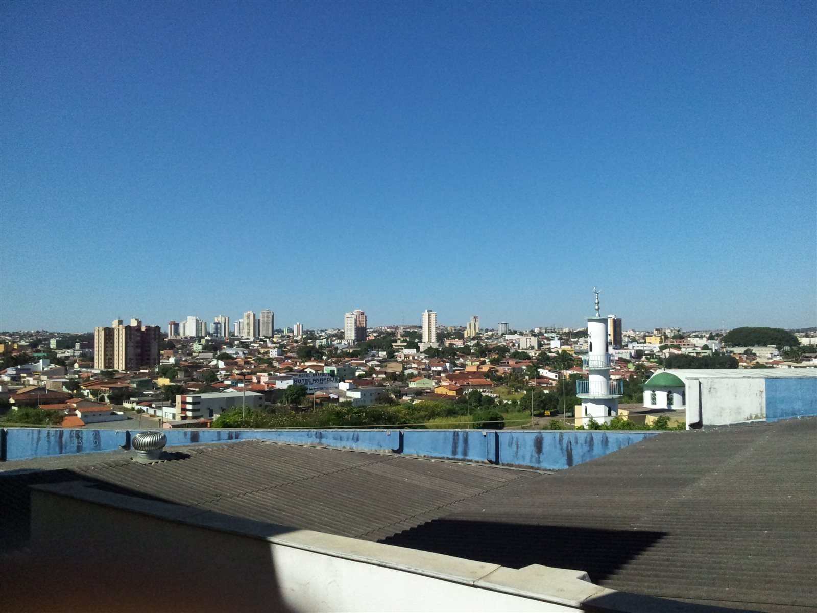 Vista de Anápolis a partir de um terraço, com edifícios ao longe e casas em primeiro plano.